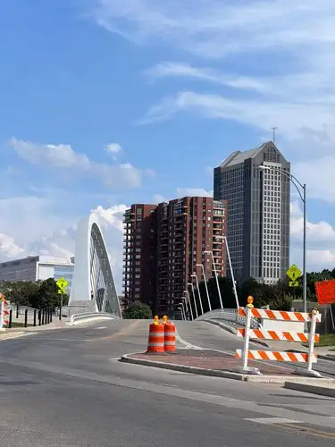 Urban curves meet towering architecture under a bright sky.